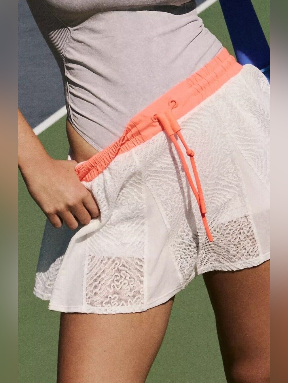 Free People Movement Good Sport Skorts in white with a neon orange waistband.